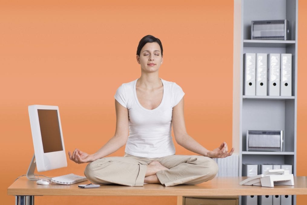 Woman doing yoga at desk