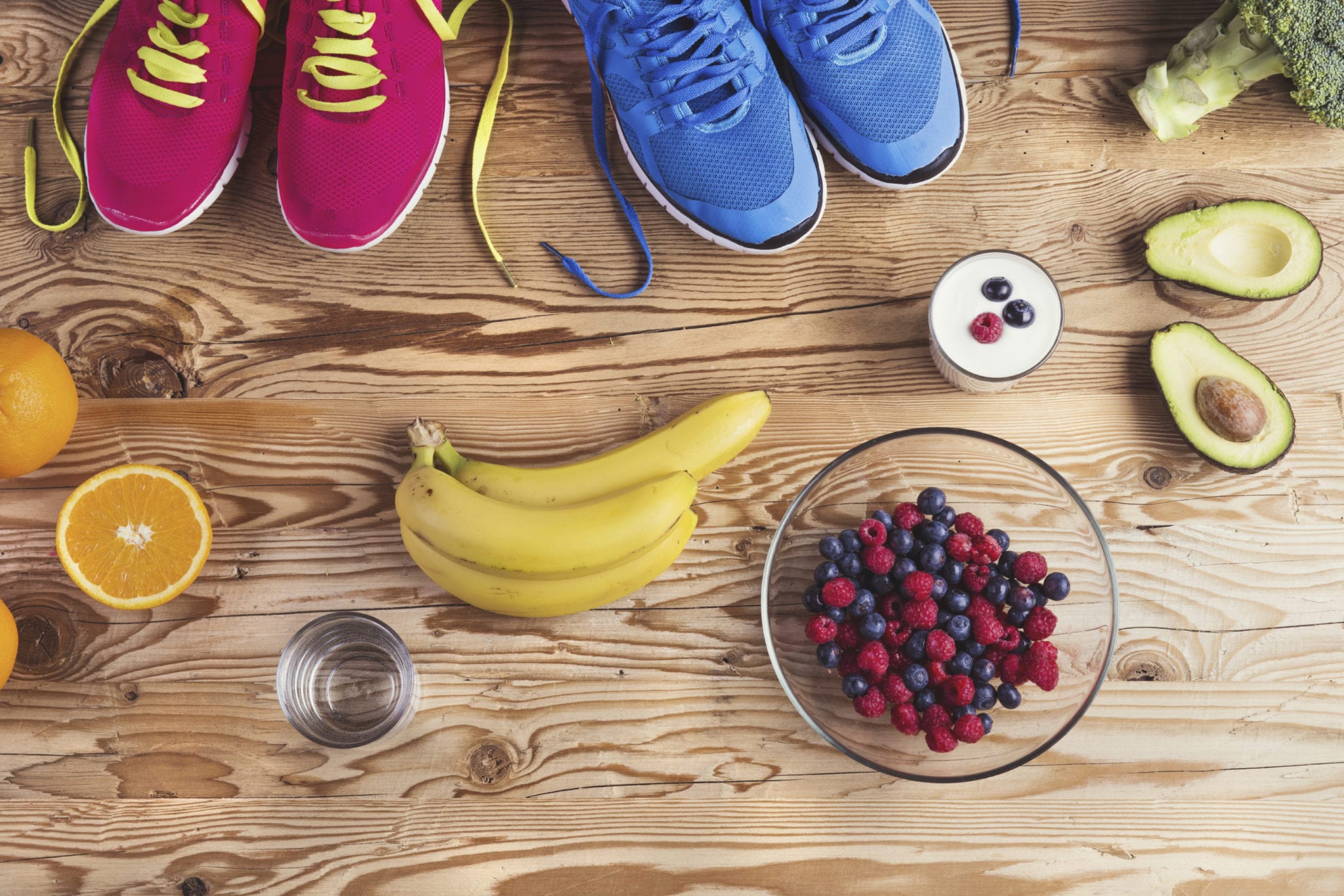 Running shoes and healthy food composition on a wooden table background