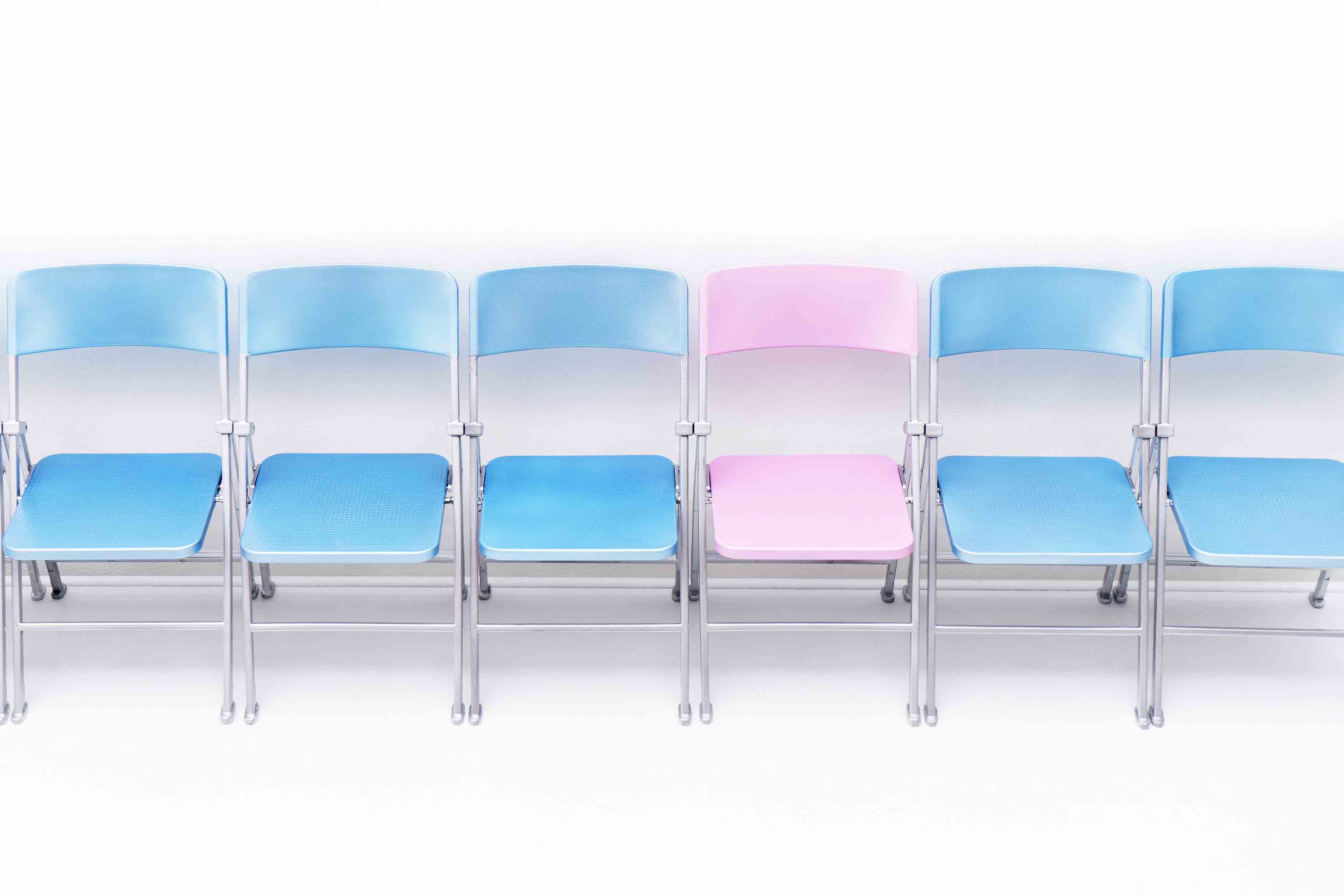 679-08718348 © Masterfile Royalty-Free Model Release: No Property Release: No One pink chair in a row of blue chairs.