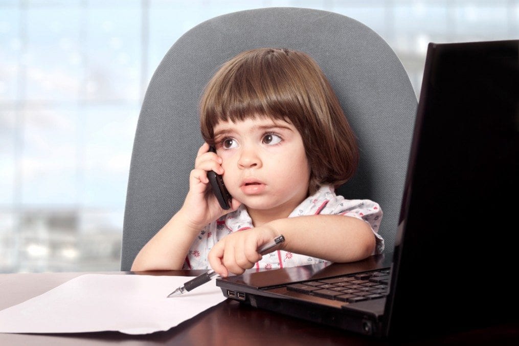 Child at desk on the phone and laptop