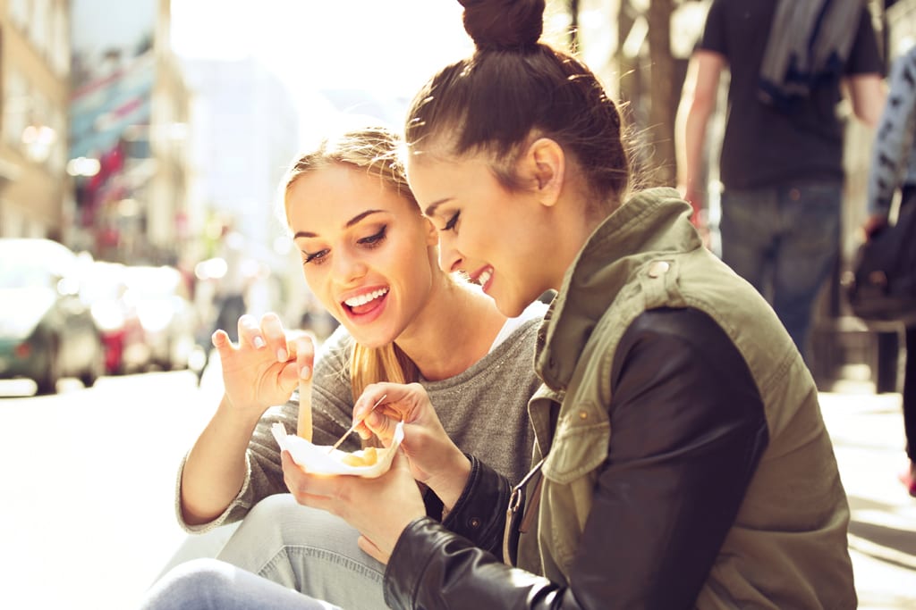 Two women eating junk food