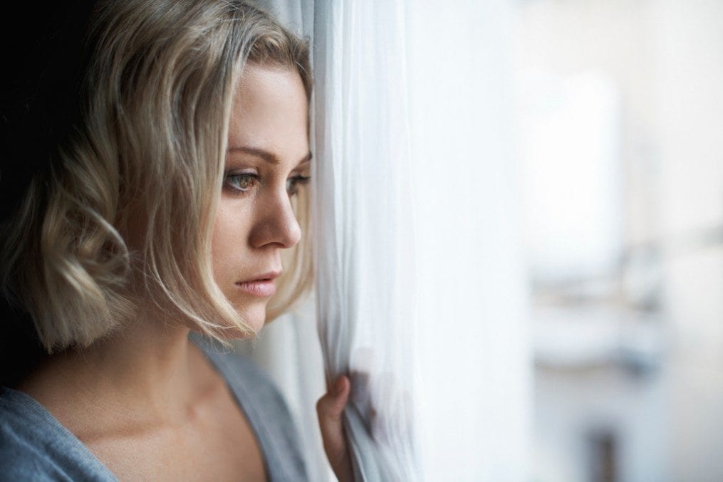 Woman with mental health issues looking out of window