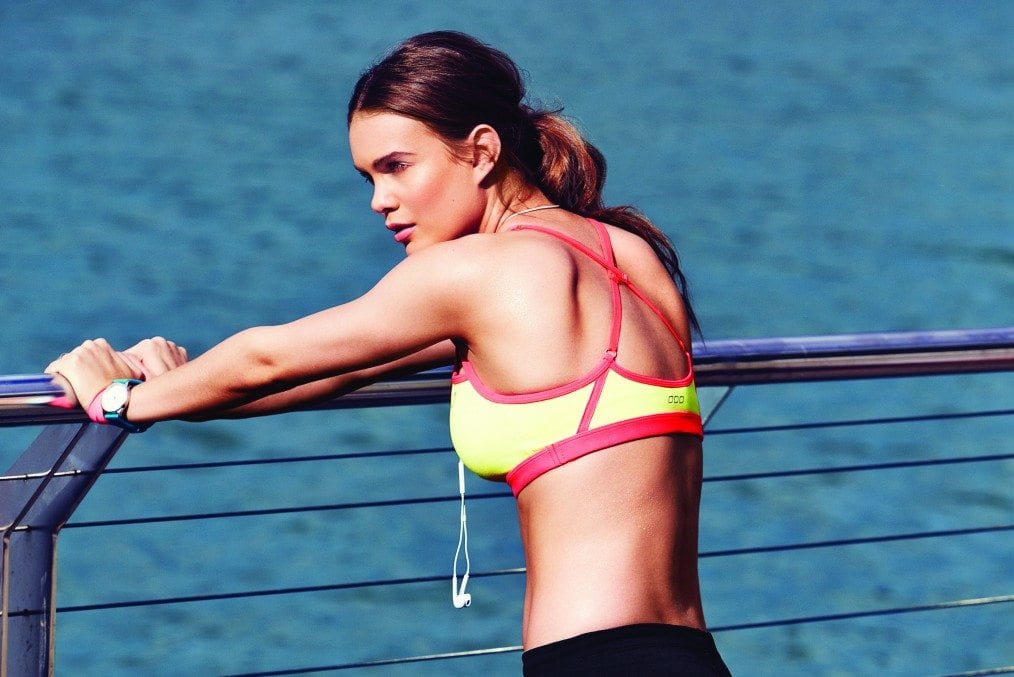 Woman in exercise gear leaning on railing