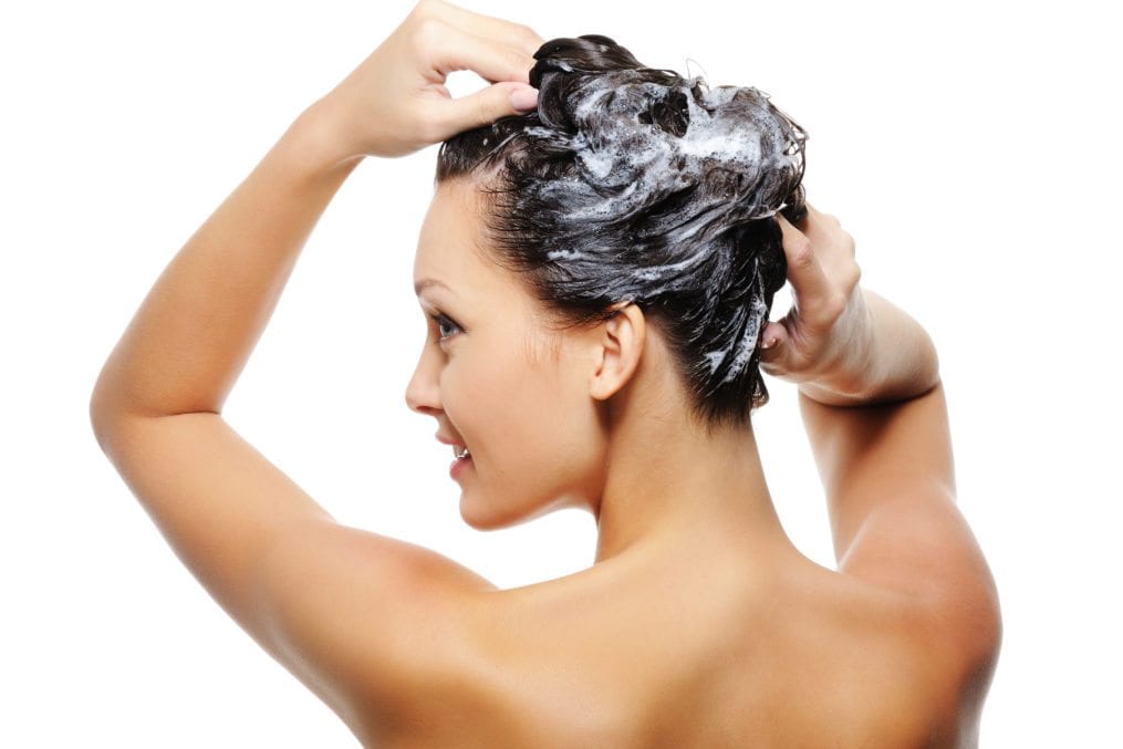Woman washing hair with Dr. Organic's Hemp based shampoo