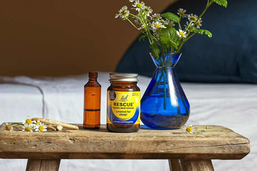 Rescue Peaceful Night Sleep Capsules next to a vase of daisies